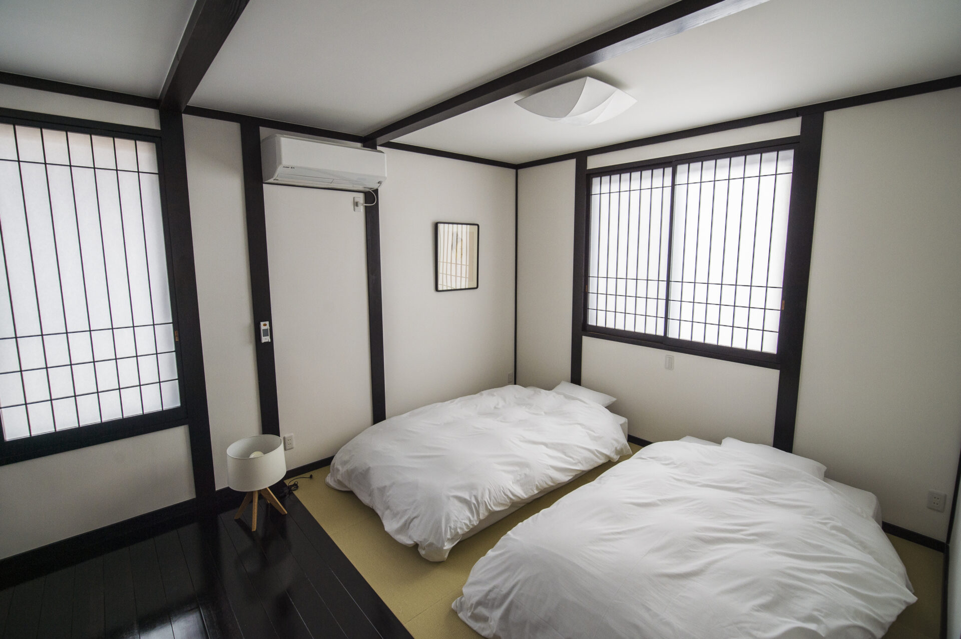 障子のある旅籠屋丸一の客室に並べられた二組の布団