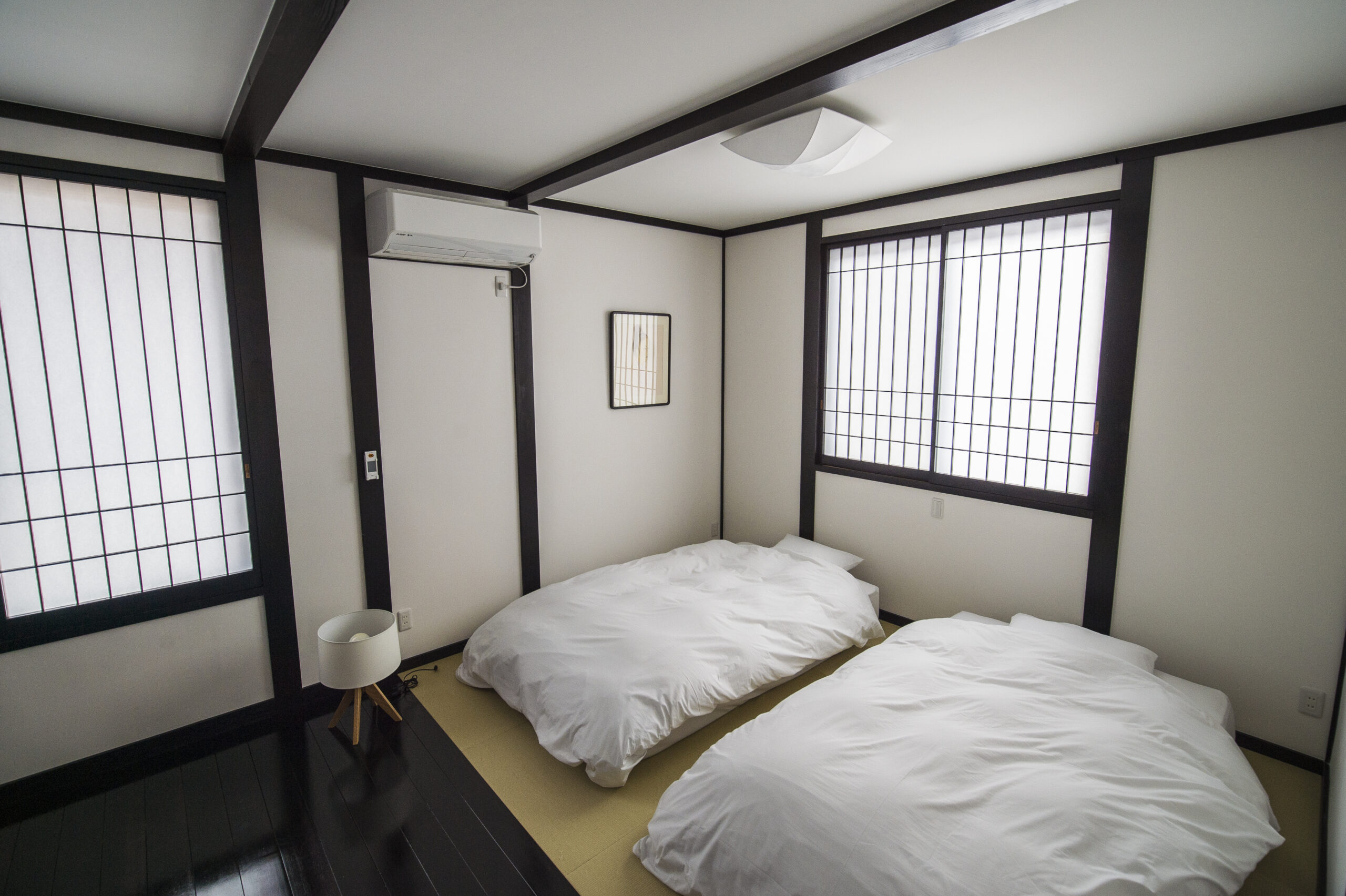 障子のある旅籠屋丸一の客室に並べられた二組の布団