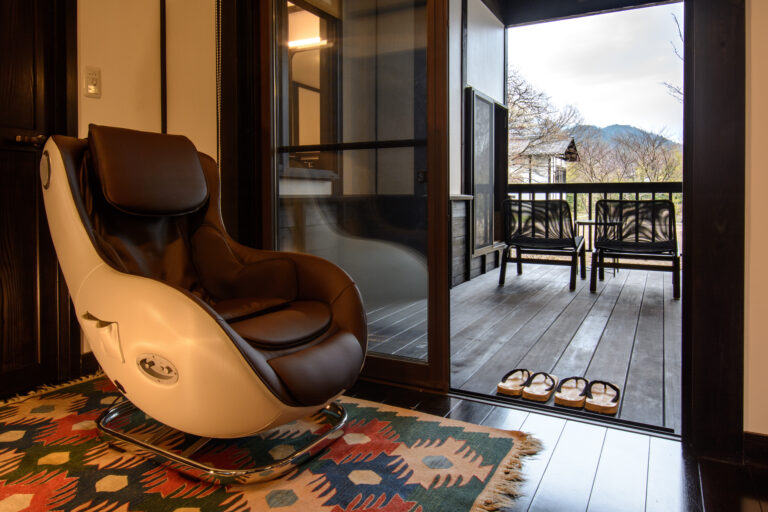 旅籠屋丸一の客室友七にあるマッサージチェアと山を望むベランダ