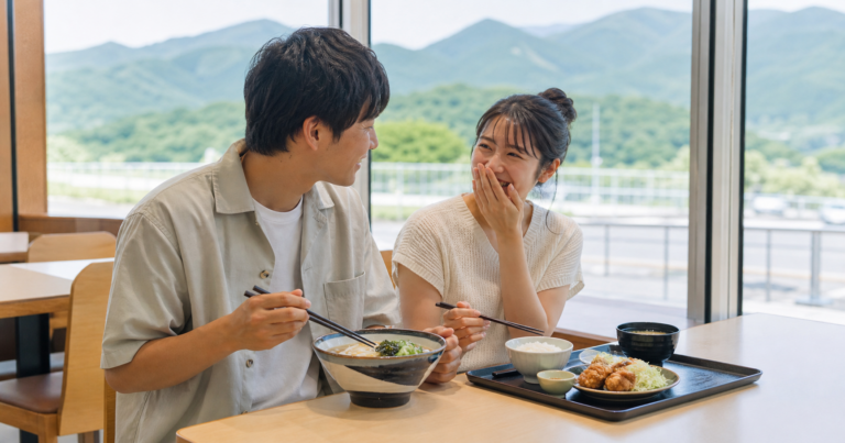 関越道のサービスエリアで昼食を楽しむカジュアルな服装のカップルの利用イメージ
