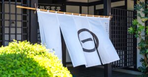 旅籠屋丸一の玄関に掛かる丸一印の白い暖簾