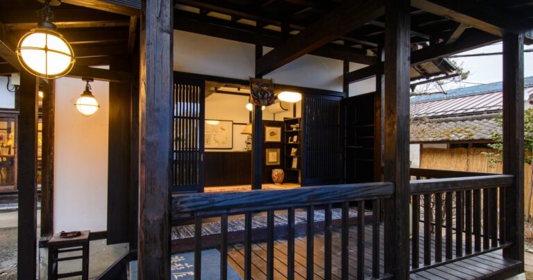 夏の夕方に灯りがともる猿ヶ京温泉の旅籠屋丸一の玄関