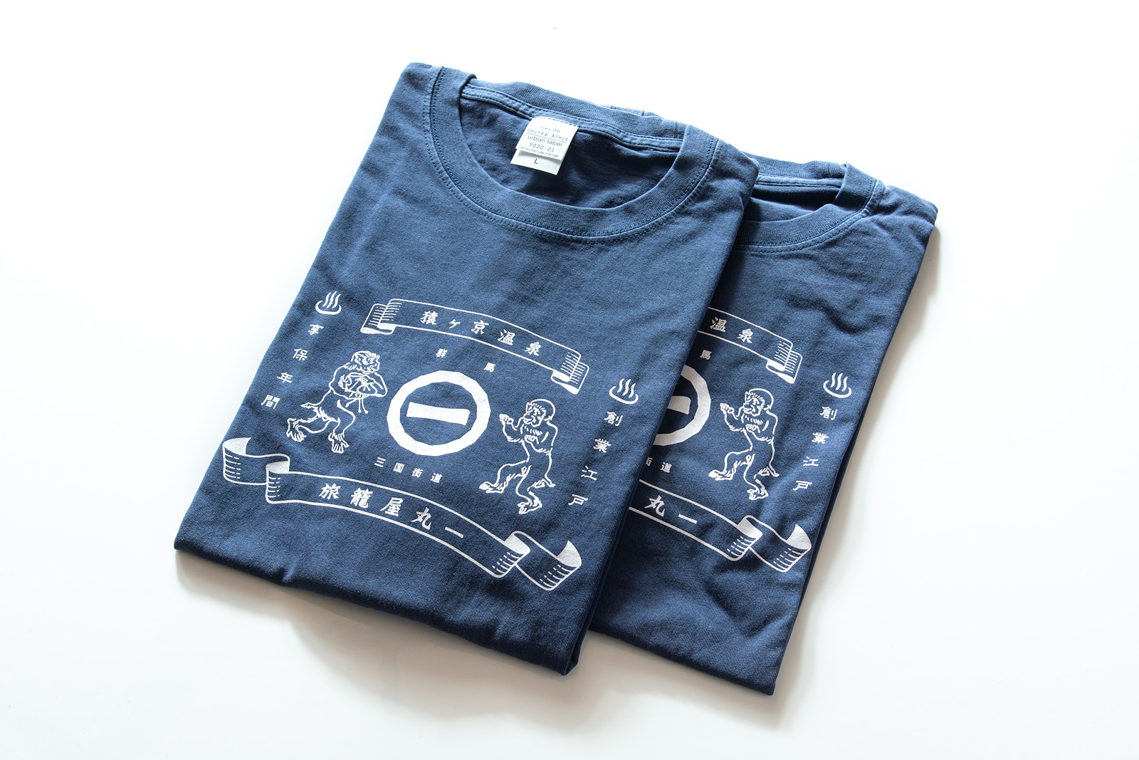 旅籠屋丸一の文字と猿ヶ京温泉の意匠を描いた藍色のTシャツ