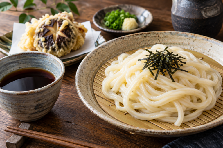 水沢うどんの昼食を思い描く、ざるに盛った白いうどんとつゆの利用イメージ