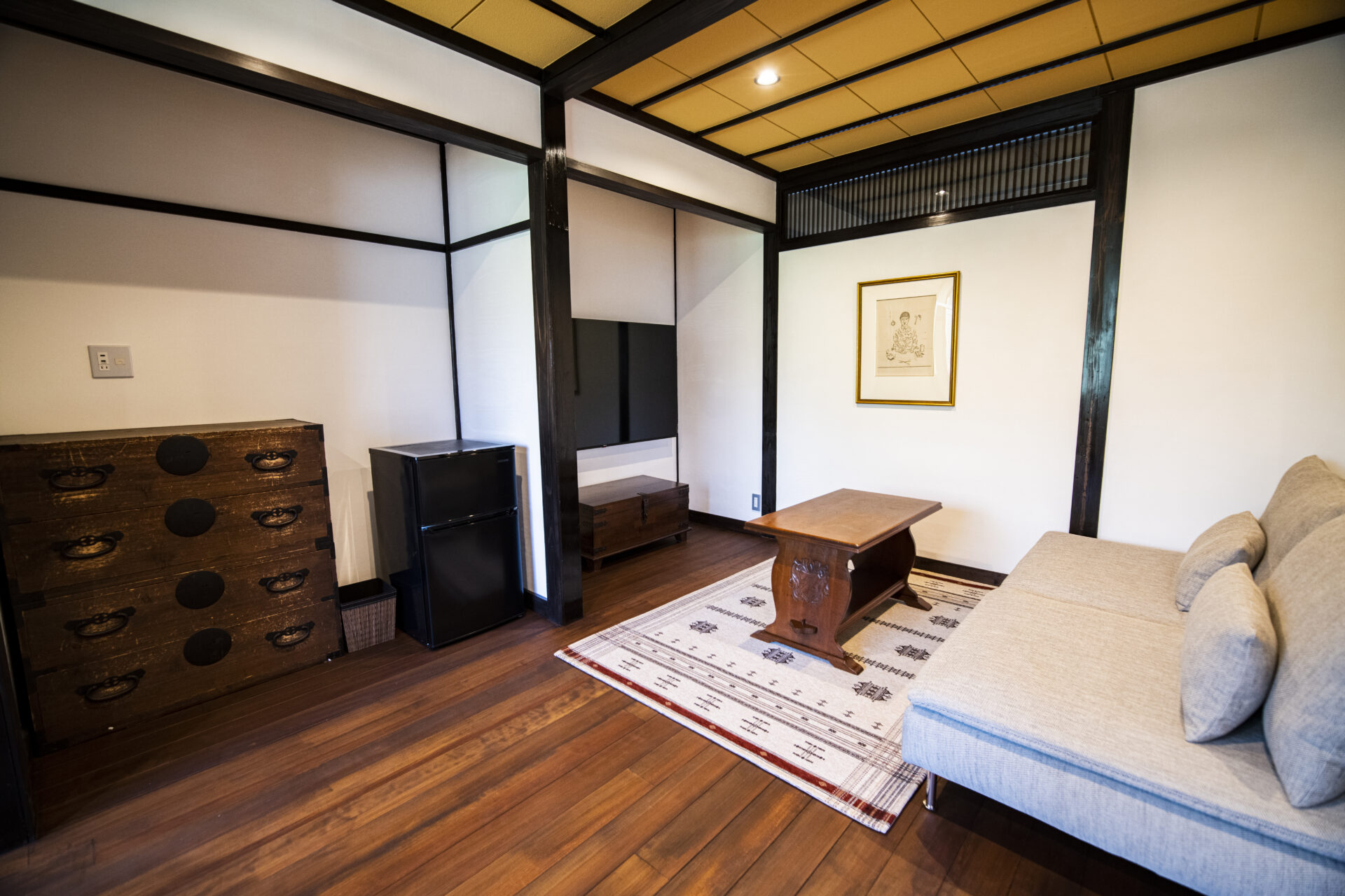 旅籠屋丸一の清逸の居間に置かれたソファと古い箪笥