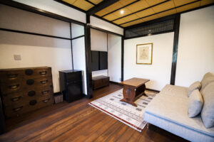 旅籠屋丸一の清逸の居間に置かれたソファと古い箪笥